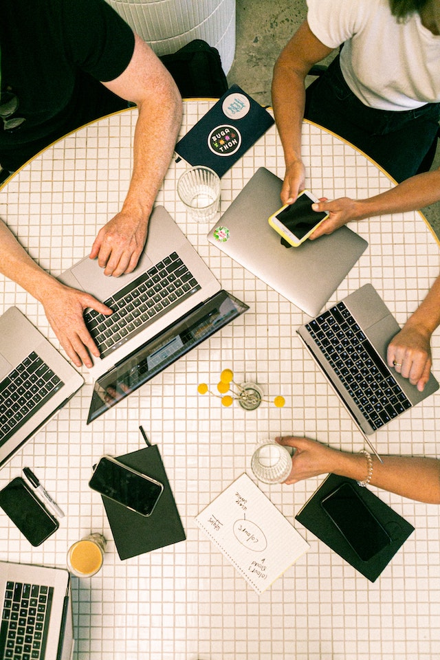 Tafel met laptops waarop marketingactiviteiten gebeuren